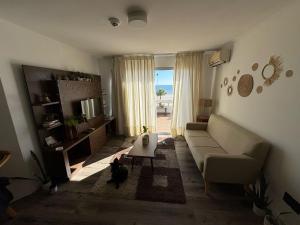 a living room with a couch and a cat in it at apto nuevo frente al mar in Piriápolis