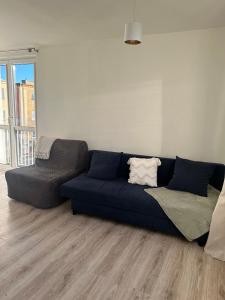 a blue couch and a chair in a living room at Apartament Lazurowy in Puck +1 photo