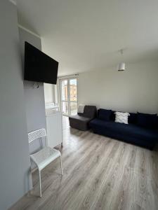 a living room with a blue couch and a chair at Apartament Lazurowy in Puck