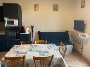 a kitchen with a table with chairs and a couch at Maison bord de mer pour 2 à 6 pers in La Tranche-sur-Mer +4 photos