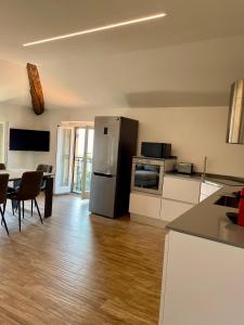 a kitchen with a refrigerator and a table with chairs at Above the lake in Varenna