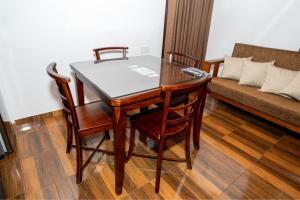 a dining room table with two chairs and a couch at Prime England Cottages in Nuwara Eliya