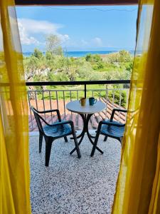 een tafel en stoelen op een balkon met een tafel en stoelen bij Firefly Studios Georgios 11 in Corfu