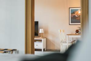 Zimmer mit einem Stuhl, einem Tisch und einem TV in der Unterkunft CASALOTTI Ferienwohnung Königsbrück in Königsbrück
