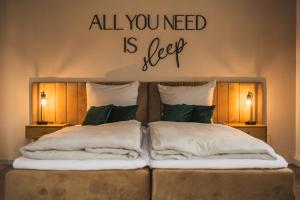 ein Bett mit einem Schild, auf dem steht: „Alles, was Sie brauchen, ist Schlaf“ in der Unterkunft CASALOTTI Ferienwohnung Königsbrück in Königsbrück