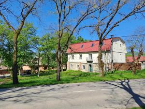 a large white house with a red roof at Penzión Pod zámkom in Halič