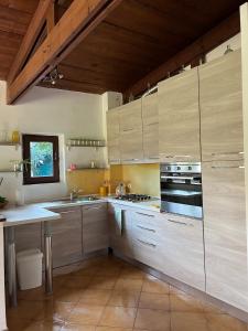 a kitchen with wooden cabinets and a stove top oven at Green Cottage in Casal Palocco