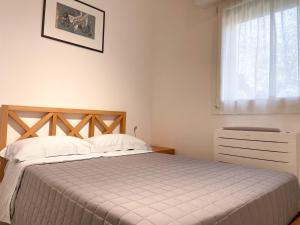 a bedroom with a bed and a window at Casetta Ortica in Montemaggiore al Metauro