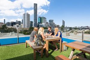 a group of people sitting at a table on a roof at Summer House Backpackers Brisbane in Brisbane