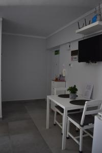 a room with a table and two chairs and a tv at Fotini's studio in Paleo Tsifliki
