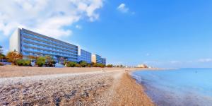 ein Gebäude an einem Strand neben dem Wasser in der Unterkunft Mediterranean Hotel in Rhodos (Stadt)