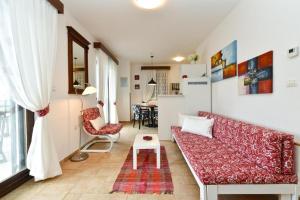 a living room with a red couch and a table at Charming apartment with balcony and pool in Peroj