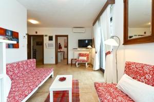 a living room with two couches and a table at Charming apartment with balcony and pool in Peroj