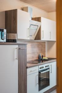 eine Küche mit weißen Schränken und einem Herd mit Backofen in der Unterkunft CASALOTTI Ferienwohnung Königsbrück in Königsbrück + 20 Fotos