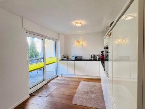 a kitchen with white cabinets and a large window at seeglueck RHEINPARADIES - Geräumige Ferienwohnung mit Wasserblick Balkon Parkplatz und Zentrumsnähe am Rheinufer in Konstanz in Konstanz