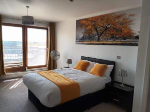 a bedroom with a bed and a large window at KCS Birmingham City Apartment with Balcony/Parking in Birmingham +9 photos