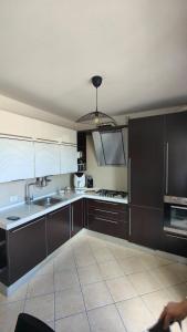 a kitchen with dark brown cabinets and a sink at Casa Plac Appartamento Panoramico- Relax Garantito in Gatteo