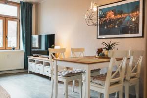 ein Esszimmer mit Tisch und Stühlen und einem Fernseher in der Unterkunft CASALOTTI Ferienwohnung Königsbrück in Königsbrück