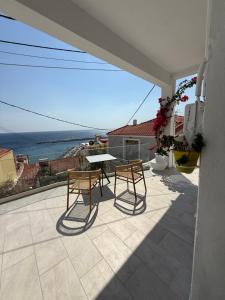 a patio with a table and chairs and the ocean at Michalelis cave & loft in Plomarion
