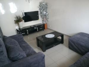 a living room with a couch and a tv at S I Appartements in Dakar