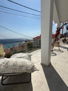 a bed on a balcony with a view of the ocean at Michalelis cave & loft in Plomarion +4 photos