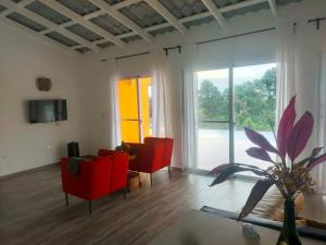 ein Wohnzimmer mit roten Sesseln und einem großen Fenster in der Unterkunft Finca Jasmat in Cabrera