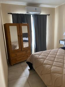 a bedroom with a bed and a dresser with a window at Departamentos Belgrano in San Luis +16 photos