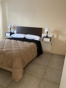 a bedroom with a large bed with two night stands at Departamentos Belgrano in San Luis