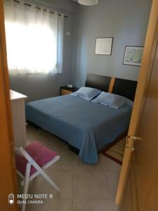 a bedroom with a bed and a chair and a window at The view! in Sarandë +16 photos