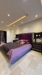 a bedroom with a large purple bed in a room at Golf View Islamabad in Islamabad