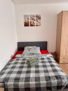 a bedroom with a bed with a checkered blanket at Gemütliches, renoviertes Appartement in Uniklinik- & City- Nähe mit Klimaanlage in Homburg
