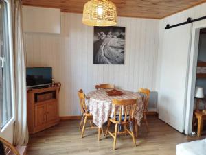 a dining room with a table and chairs at Cozy studio à coté du lac in Jausiers