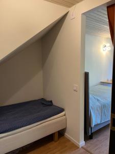 a small bedroom with a bed and a mirror at Apartment , wooded area lake, sea ,golf and shopping malls Askim domarings väg 154 in Askim