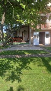 a house with a tree in front of a yard at Cute lodge in Zeta in Mahala