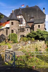 uma casa grande com uma bandeira em frente em Hotel Burg Arras em Alf
