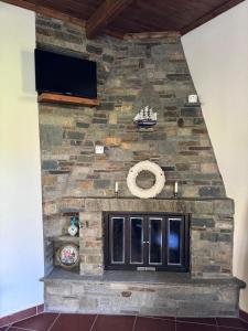 a stone fireplace with a tv on top of it at Matias Kastanies Appartements with privat parking in Rachonio
