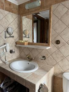 a bathroom with a sink and a mirror at Matias Kastanies Appartements with privat parking in Rachonio