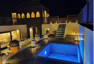 a swimming pool in the middle of a house at night at Riad Callas in Essaouira