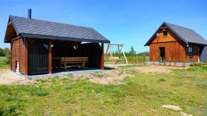 a small building with a bench in a field at Malinówka Kruczy Borek in Kruczy Borek +43 photos