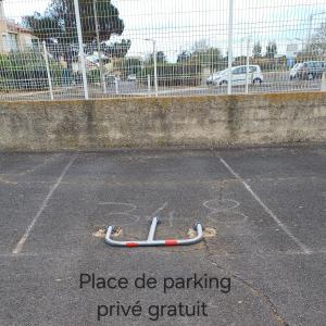 a baseball bat in a parking lot next to a fence at Appartement à Marseillan plage accès direct à la plage in Marseillan