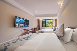 a bedroom with two beds and a flat screen tv at Mare Nubium Resort in Zhangjiajie