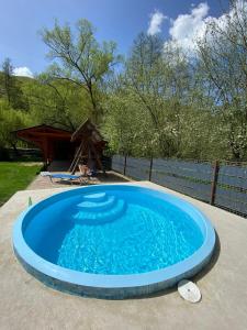 a large blue swimming pool in a backyard at Pensiunea Valea Tonii in Strungari