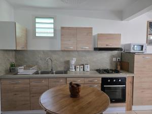 a kitchen with a wooden table and a wooden counter top at L'Eveil des Sommets in Salazie +8 photos