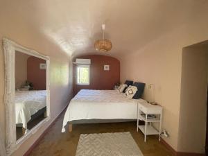 a bedroom with a white bed and a mirror at Maison des Bourgades in Saint-Julien-de-Peyrolas +40 photos