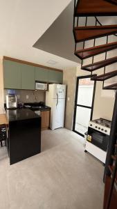 a kitchen with a stove and a white refrigerator at Casa cocais Atins in Barreirinhas