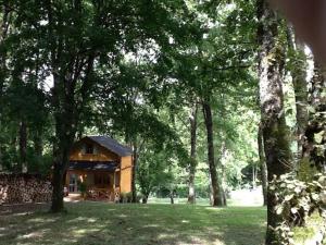 a small wooden cabin in a field with trees at Le Clos de Mesvres in Civray-de-Touraine