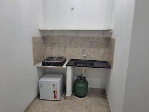 a small kitchen with a sink and a stove at Kitnets Oceanos in Caraguatatuba