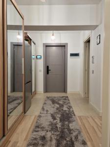 a hallway with a mirror and a door and a rug at Apartament Lory in Iaşi