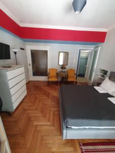 ein Schlafzimmer mit einem Bett und einem roten Streifen an der Wand in der Unterkunft Smart cozy apartment in Athens! in Athen