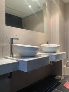a bathroom with two sinks and a large mirror at Ecrin Moderne Islan a Agadir in Agadir +20 photos